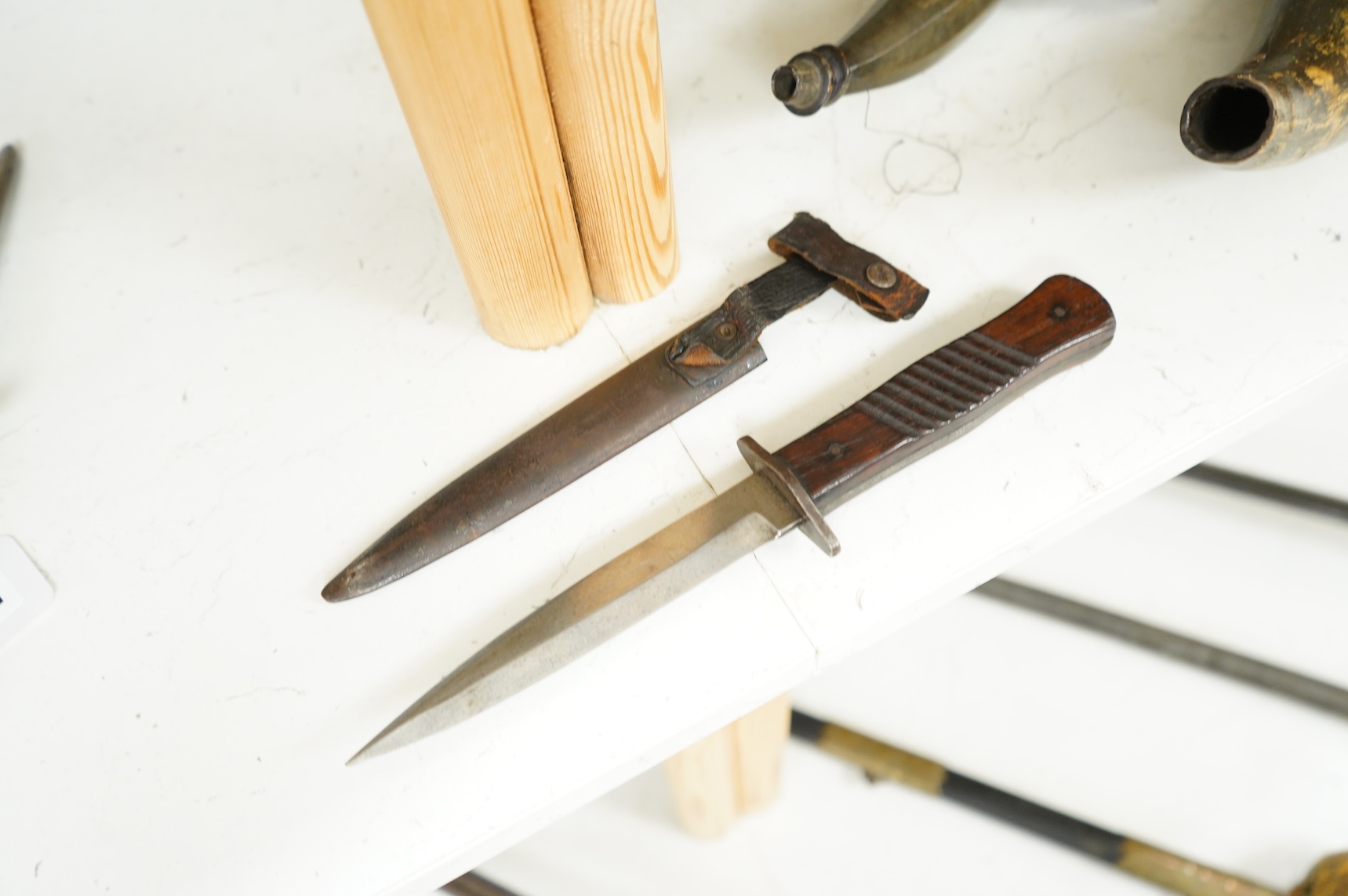 A First World War German Fighting Knife, with two piece wooden grip and steel cross guard, in original steel scabbard with leather belt loop mount, single edged blade with makers mark to one side; Gottlieb Hammesfahr, So